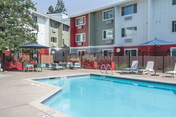 A swimming pool in front of apartment buildings.